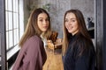 Sad and cheerful young women posing in a loft apartment room.