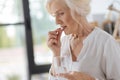 Sad cheerless woman putting a pill to her mouth Royalty Free Stock Photo