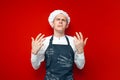 Sad chef cook crying on red isolated background, frustrated kitchen worker in uniform in stress