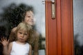 Sad child behind the window on rainy day