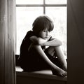 Sad child, boy, sitting on a window shield Royalty Free Stock Photo