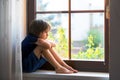 Sad child, boy, sitting on a window shield Royalty Free Stock Photo