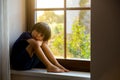 Sad child, boy, sitting on a window shield Royalty Free Stock Photo