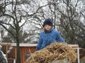 Sad child carries a cart of straw.