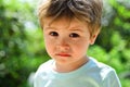 Sad child, close-up portrait. A frustrated child without mood. Sad emotions on a beautiful face. Child in nature Royalty Free Stock Photo