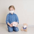 Sad child girl in protective medicine mask plays with toys in medical masks. Virus protection concept Royalty Free Stock Photo