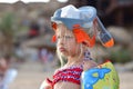 Sad child girl in a water mask stands on the beach