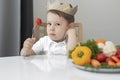 a sad child holds a tomato on a fork, an unhappy little boy refuses to eat vegetables, do not like to eat vegetables Royalty Free Stock Photo