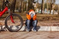 Sad child sitting near a broken bicycle