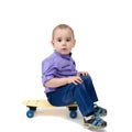 Sad child sitting on a skateboard Royalty Free Stock Photo