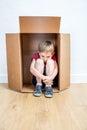 Sad child thinking hunched in a box, away from shyness Royalty Free Stock Photo