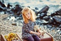 Sad child with a toy sitting on a suitcase on the beach Royalty Free Stock Photo