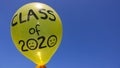 A sad `Class of 2020` balloon against a blue sky, with lots of copy space. Concept of cancelled graduation ceremonies due to Covid