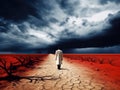 Sad climatologist walking in the eerie and dry land. Climate change concept