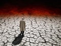 Sad climatologist walking in the eerie and dry land. Climate change concept