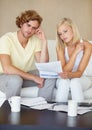 Sad couple, bills and documents stress on sofa in debt, financial planning and budget risk or worry at home. Young woman Royalty Free Stock Photo