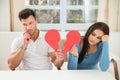 Sad couple holding broken heart Royalty Free Stock Photo