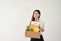 A sad and crying Asian female office worker is carrying a cardboard box with her resignation letter Royalty Free Stock Photo