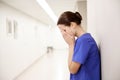 Sad or crying female nurse at hospital corridor Royalty Free Stock Photo