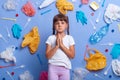 Sad crying little girl dressed casually standing with palms together, praying for Earth, looking at camera with pout lips, prays Royalty Free Stock Photo