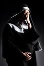 Sad crying pregnant nun touching tummy