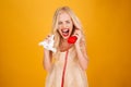 Sad crying screaming young blonde woman talking by telephone. Royalty Free Stock Photo