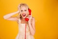 Sad crying screaming young blonde woman talking by telephone. Royalty Free Stock Photo