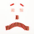 Sad and crying smile made from many pills capsules. wellness concept