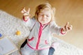 Sad crying toddler girl learning painting with felt tip pens. Little baby child drawing on hands and clothes. Angry Royalty Free Stock Photo