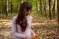 sad crying woman in park young beautiful woman with autumn leaf stand in autumn park in sun shines. Royalty Free Stock Photo