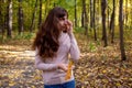 sad crying woman in park young beautiful woman with autumn leaf stand in autumn park in sun shines. Royalty Free Stock Photo