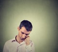 Sad, depressed, alone, man resting his head on hand looking down Royalty Free Stock Photo