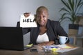 Sad and depressed black afro American woman suffering stressed at office working with laptop computer feeling overwhelmed asking f Royalty Free Stock Photo