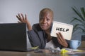 Sad and depressed black afro American woman suffering stressed at office working with laptop computer feeling overwhelmed asking f