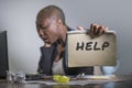 Sad and depressed black afro American woman suffering stressed at office working with laptop computer feeling overwhelmed asking f Royalty Free Stock Photo