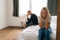 Sad depressed stubborn couple sitting separate on bed turn back ignore each other after fight. Angry man and upset woman Royalty Free Stock Photo