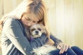 A sad or depressed teenage girl hugging a small dog Royalty Free Stock Photo