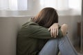 Sad depressed teenager girl sitting on floor indoors, hiding face Royalty Free Stock Photo