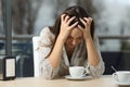 Sad and depressed woman alone in a coffee shop