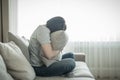 Sad depressed woman at home sitting on couch and hugging a pillow, loneliness and sadness concept Royalty Free Stock Photo