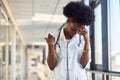 Sad and depressed young african american female doctor in white uniform standing in corridor Royalty Free Stock Photo