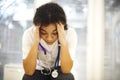 Sad depressed young african american nurse sitting with frustrated face expression