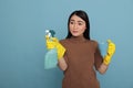 Sad depressed young housekeeper asian holding a spray and coffee cup Royalty Free Stock Photo