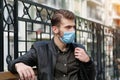 Sad depressed young man in medical protective face mask sits on the bench Royalty Free Stock Photo