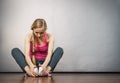 Sad depressed young teenage girl sitting by wall Royalty Free Stock Photo