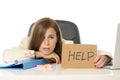 Sad desperate businesswoman in stress at office computer desk holding help sign Royalty Free Stock Photo