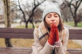 Sad devastated young woman sitting on bench in autumn park crying and praying. Mental health and religion Royalty Free Stock Photo