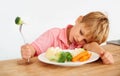 Sad, diet and a child with vegetables for dinner, unhappy meal and problem with food. Frustrated, hungry and dislike of Royalty Free Stock Photo