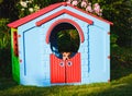 Sad dog feeling anxiety hiding in children playhouse at backyard