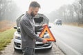 Sad driver having engine problem standing near broken car on the road. Car breakdown concept Royalty Free Stock Photo